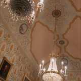 Lasciamo il piccolo locale per entrare in un luogo la cui maestosit� � anticipata da tre monumentali lampadari in cristallo e ottone. Siamo nella "Sala delle feste", la pi� sontuosa, dedicata alla pinacoteca della Reggia di Caserta